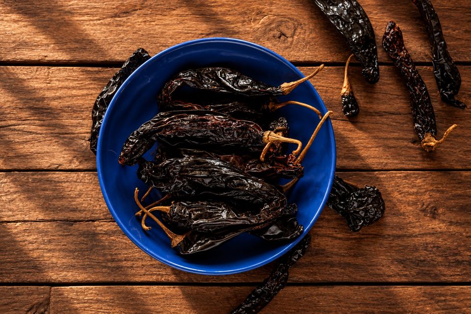 Dlouhé tmavé sušené chilli v modré misce